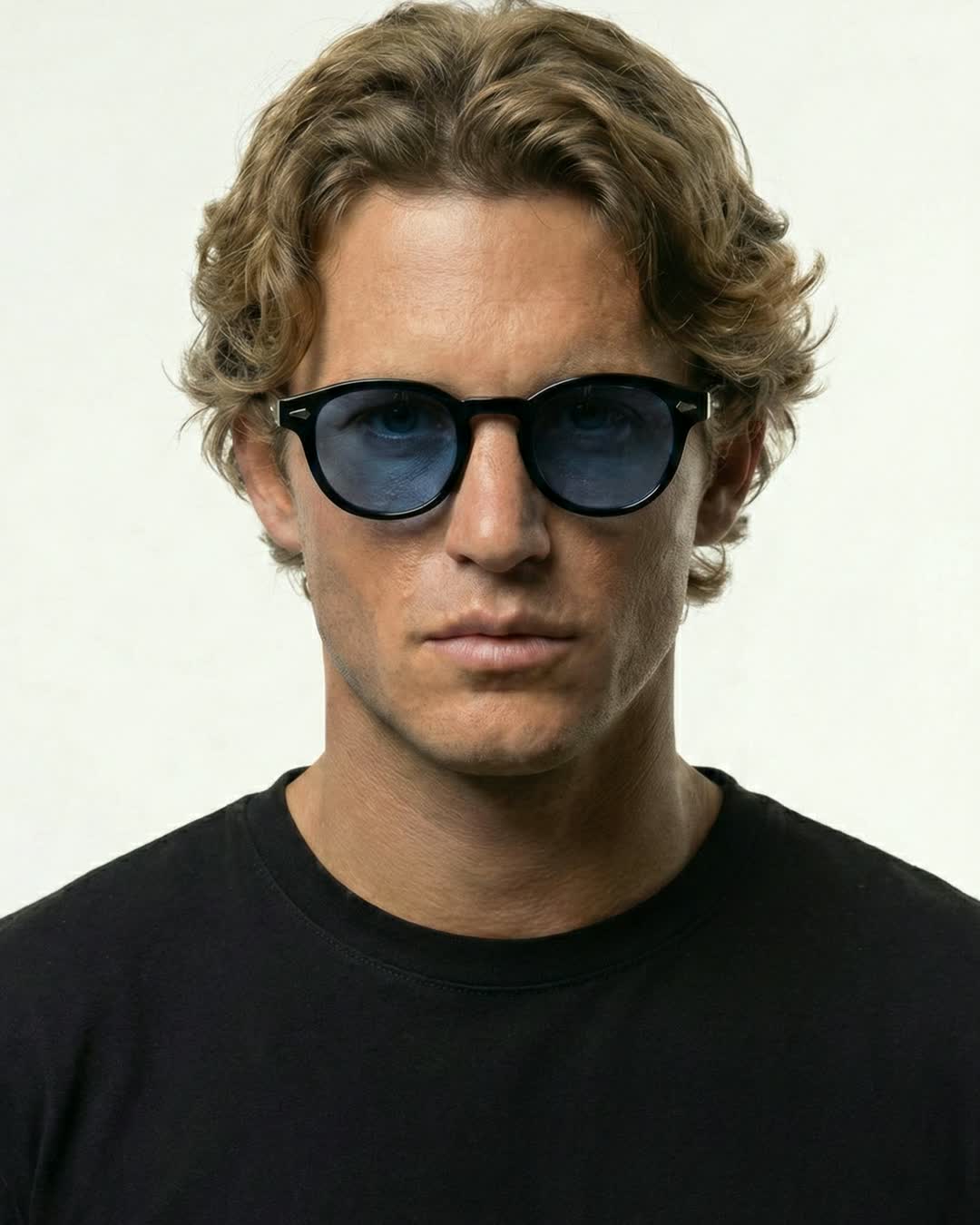 Man wearing Aura Eyes blue-tinted round sunglasses, studio portrait